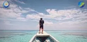 Cuplikan dokumenter: seorang pria berdiri di haluan perahu di laut dangkal
