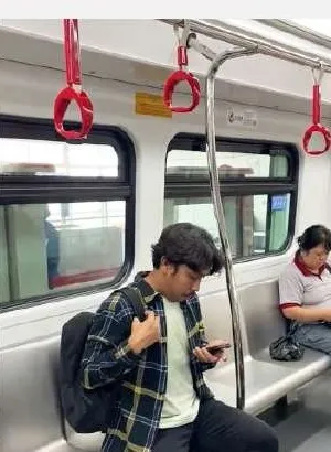 Penumpang menggunakan ponsel di dalam kereta LRT Jakarta